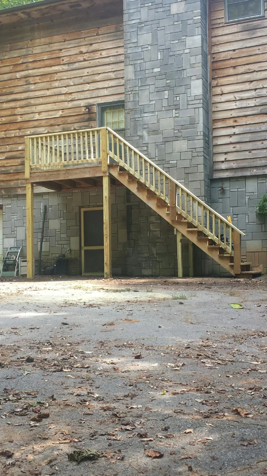 New pressure treated deck and stair landing on a log home in Parkton