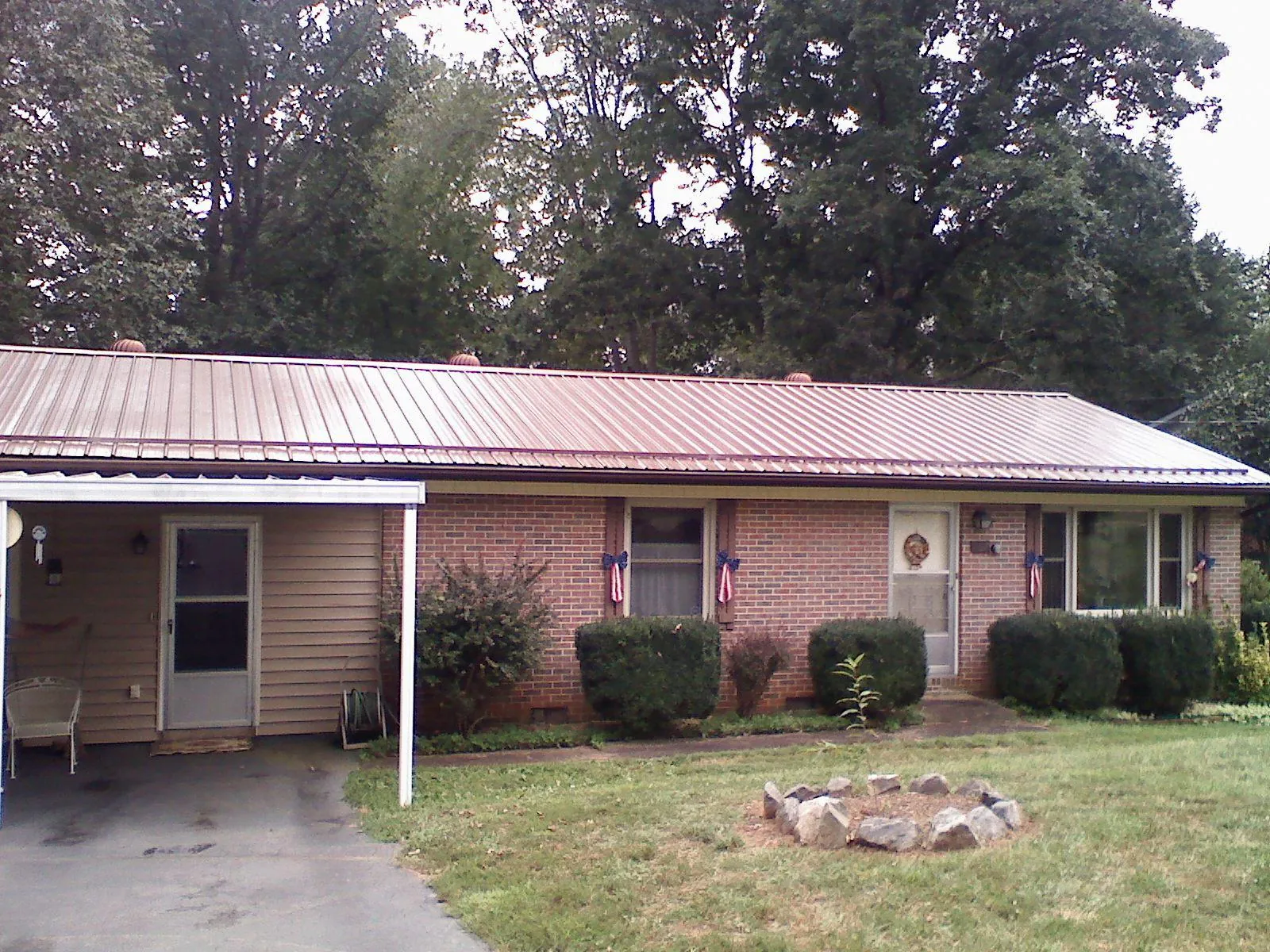 Bronze metal roof and carport on a brick ranch home — Roof Repair work by our crew in Parkton